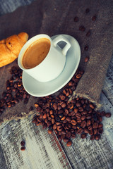 Cup of tea with autumn decor on wooden table.