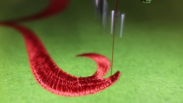 fast Sewing machine while embroidering with red thread 