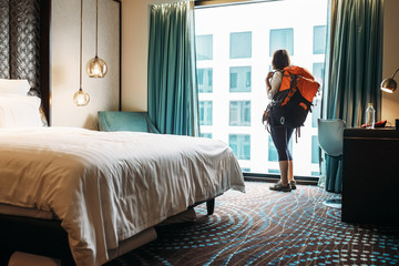 Woman backpacker traveler stay in high quality hotel room - obrazy, fototapety, plakaty