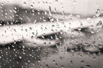 Defocused view of airplane wing through passenger window with rain drops. Processed with vintage style
