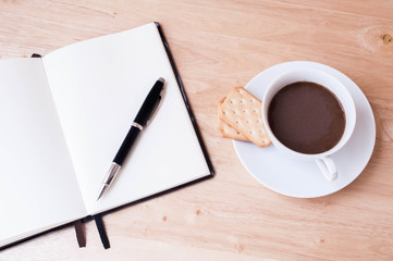 Writing in blank book on wooden table