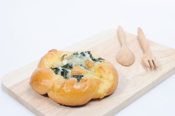 Spinach bread on chopping wood with fork and spoon