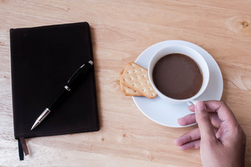 Writing in blank book on wooden table