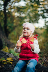 little girl in the red in the autumn forest, park