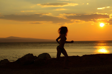 woman silhouette in sunset beach