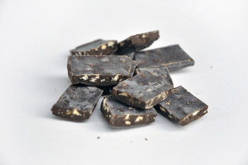 dark chocolate pieces on white background