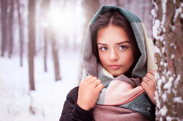 Beautiful brunette stands in a winter forest