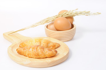 Double croissants and fresh eggs with wooden ware