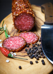 dried salami crusted in ground red pepper on dark background