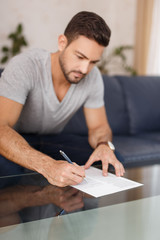 Young man filling model release on glass desk