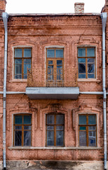 facade of the old red brick house with a balcony