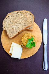 Serve beef pate with a piece of butter and bread on a wooden board, decorated with parsley