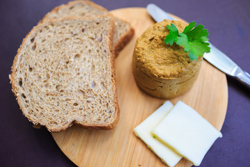 Serve beef pate with a piece of butter and bread on a wooden board, decorated with parsley