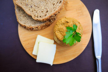 Serve beef pate with a piece of butter and bread on a wooden board, decorated with parsley