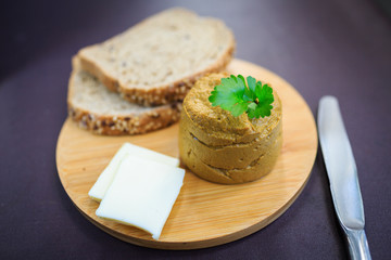 Serve beef pate with a piece of butter and bread on a wooden board, decorated with parsley