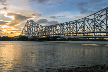 Howrah Bridge on river Hooghly at sunset. Howrah Bridge is a cantilever bridge with a suspended span over the Hooghly River in West Bengal, India. © Roop Dey