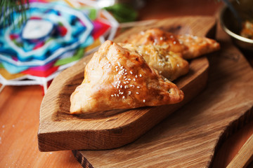 pies samosas with vegetables on a wooden board still life in