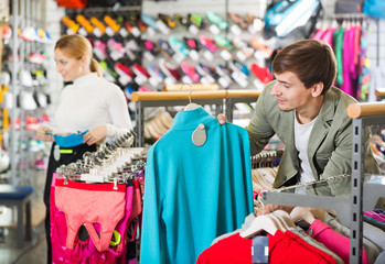 Fototapeta na wymiar Man and woman choosing sport clothing