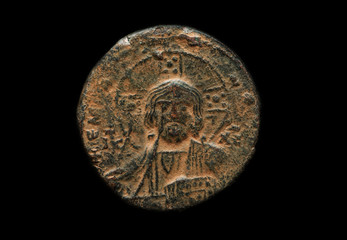 Ancient copper coin with saint portrait on it