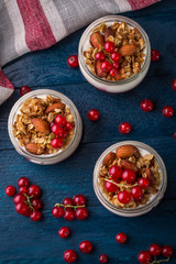 Granola breakfast decorated with berries on the navy-blue background with kitchen towel