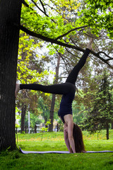 Young woman doing yoga in morning park