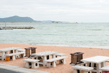 Dining tables located on sand beach by sea