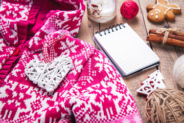 Christmas set. Warm blanket, sweater, candle, notebook, spices, cinnamon, pine cones, heart  on the wooden background