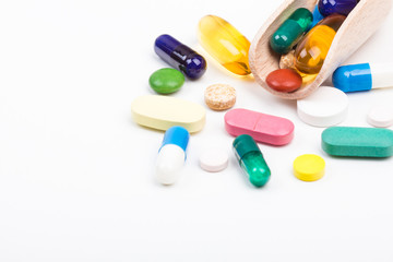 Various color pills and capsules with wooden dispencer
