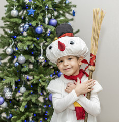 Boy in carnival costumes of snowmen. Stand hold hands before the Christmas fir-tree.