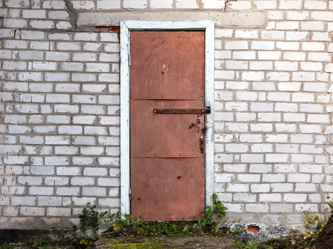 Old weathered barn door and brick wall.