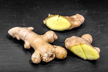 Cut ginger root on dark background, spice in cuisine for healthy cooking, seasoning ingredient
