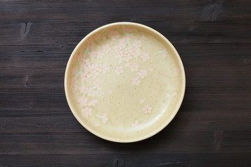 top view of green plate on dark brown table