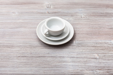 one white cup with saucers on gray brown board