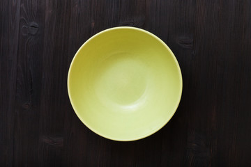 top view of green bowl on dark brown table