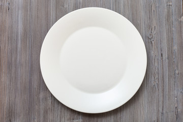 above view of white plate on gray brown table