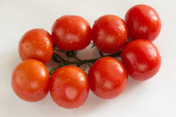 Red tomatoes with green leaves. Top view. White background