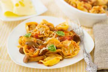 Homemade raviloi tortellini with tomato sauce with mushrooms
