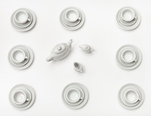 above view cups with saucers and teapot on white