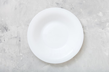 top view of white deep plate on concrete board