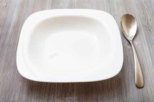 white square bowl and spoon on gray brown table