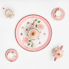 pink porcelain tea set on white paper background
