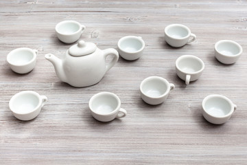 white ceramic cups and teapot on gray brown table