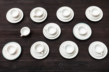 above view of cups and saucers on dark brown board