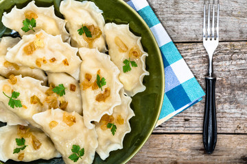 Homemade dumplings with fried onion on plate, top view, cooking concept