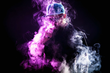 Men with beard  in sunglasses vaping and releases a cloud of vapor.