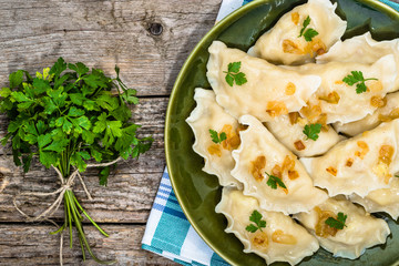 Homemade dumplings with fried onion on plate, top view, cooking concept