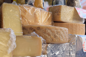 Background with different solid cheeses in a Italian street Market