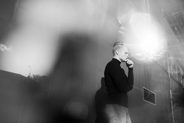 Black and white artistic photography. Young blonde man standing on street