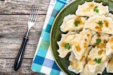 Homemade dumplings with fried onion on plate, top view, cooking concept