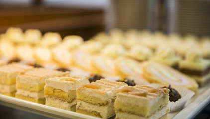 Pastry on big plate placed one beside another in straight lines